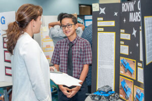 IPA middle grade science and innovation fair with teacher and student.