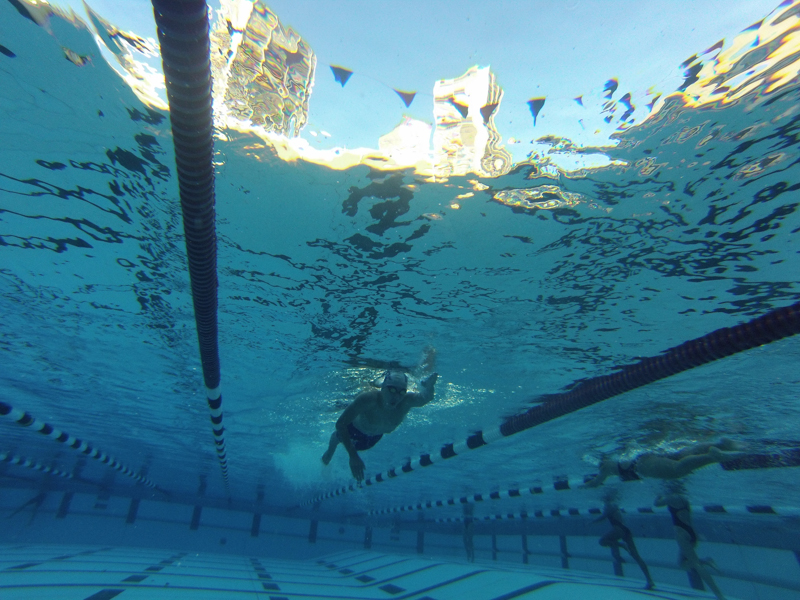 athletic swimming image taken from below with a person swimming in a pool