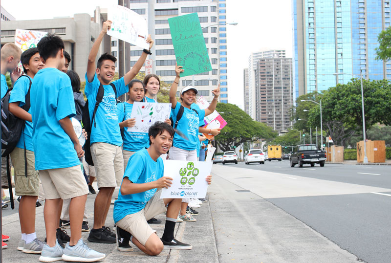 IPA 8th graders hold signs promoting clean transportation at Clean Energy Day at the Hawaiʻi State Capitol.