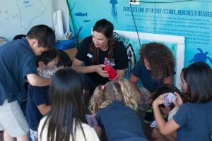 Sarah teaches IPA 2nd graders about the different recycling codes found on plastic containers.