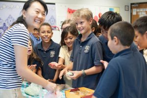 Mandarin teacher smiling with students.