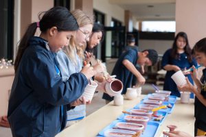 Students glaze ceramic pots.