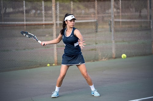Girls' varsity tennis player hitting forehand