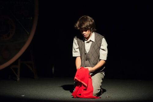 Student actor alone on stage under spotlight
