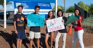 Students hold signs for free benefit concert