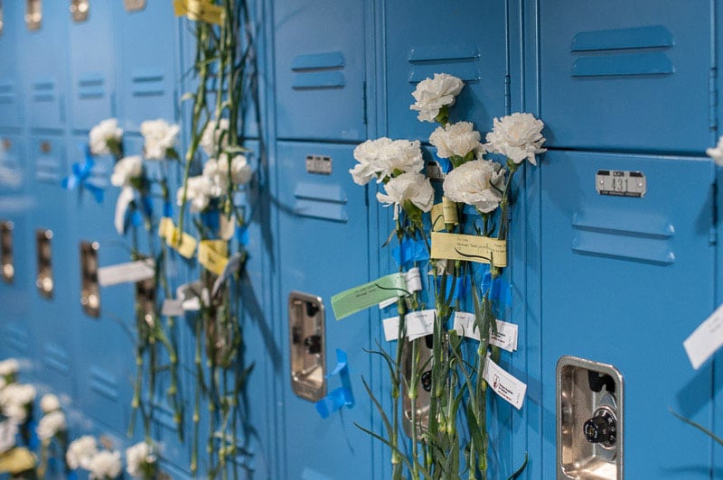 White carnations taped to student lockers