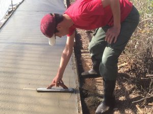 Ashton Yamamura smooths the wet concrete