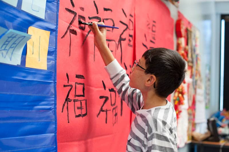 Student in Mandarin practices calligraphy