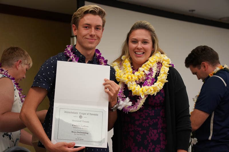 Swimmer with coach showing off certificate