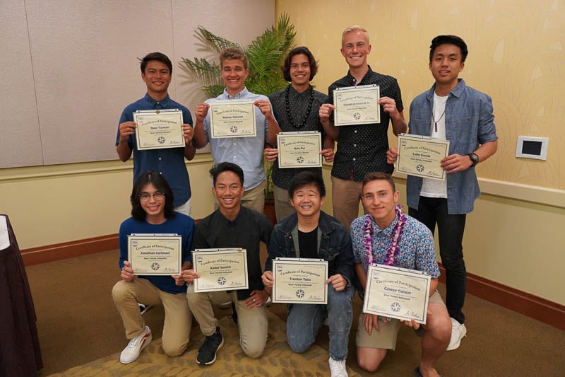 Boysʻ varsity volleyball team with certificates