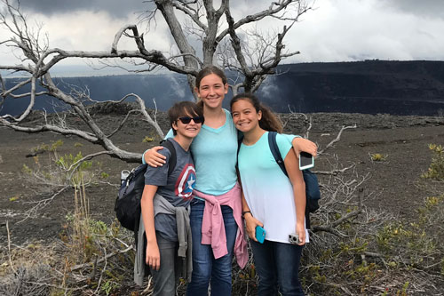 Middle school students standing near edge of volcanic crater