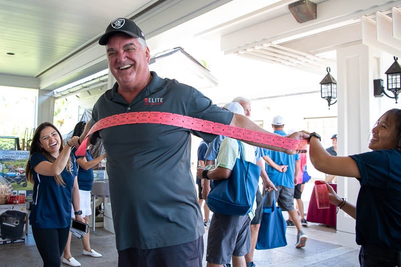 Golfer spreads arms to measure out raffle tickets