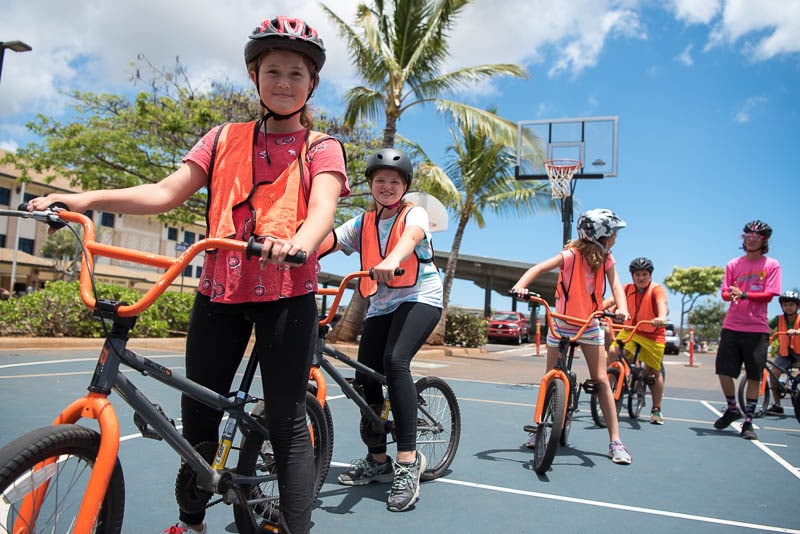 Grade 4 students in helmets and safety vests on their bikes