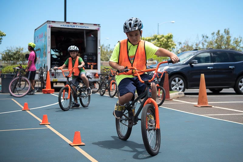 A Grade 4 student rides bike through cones
