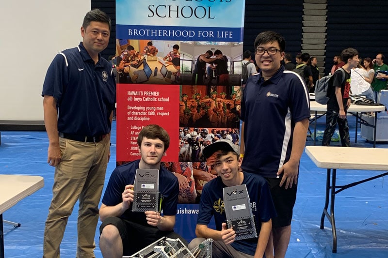 IPA Navigator Robotics team members and coach pose with tournament awards and robots