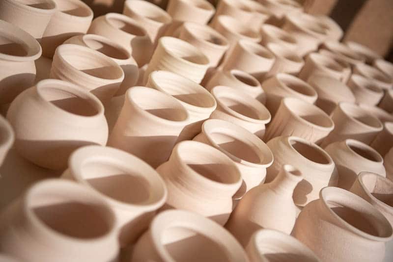 Table full of unglazed ceramic pots