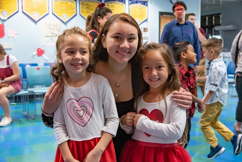 Senior student with kindergarteners at Valentine's dance