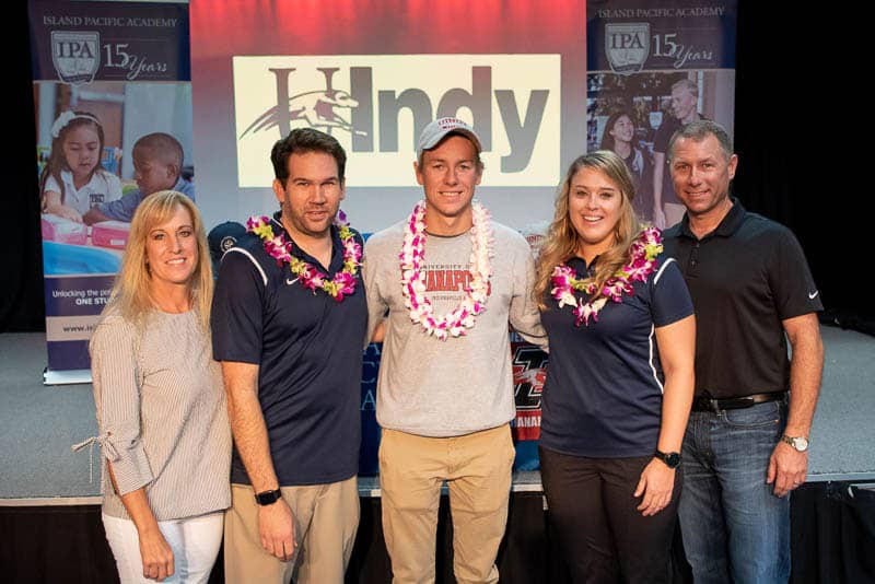 Swimmer with coach and family at letter of intent signing