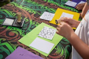 Students using stamps carved from bamboo to decorate paper