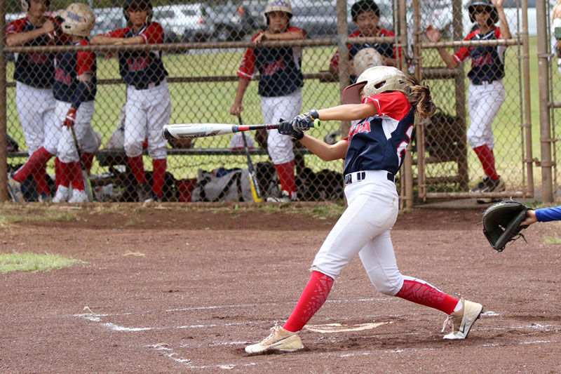 Middle school female baseball player at bat