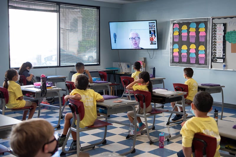 Students watch virtual ceremony in class.