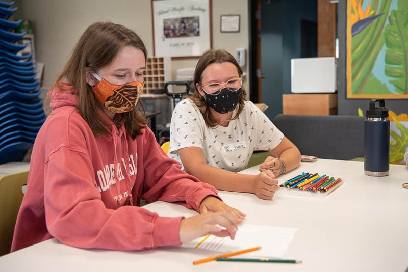 Two students working together at a table