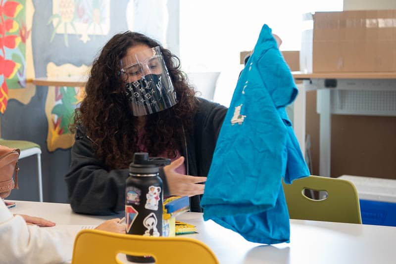 Student holds up a t-shirt