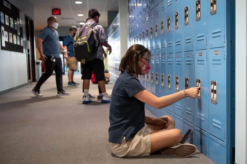 Grade 8 student opening locker