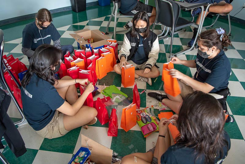 Students sitting in a circle filling treat bags