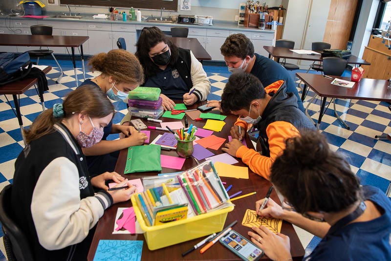 Students around a table creating cards