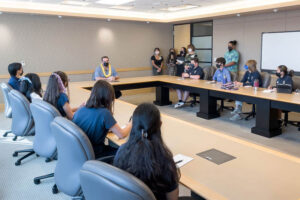 Students in boardroom with HPH CEO Ray Vara