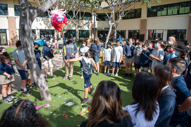 Students hitting piñatas.
