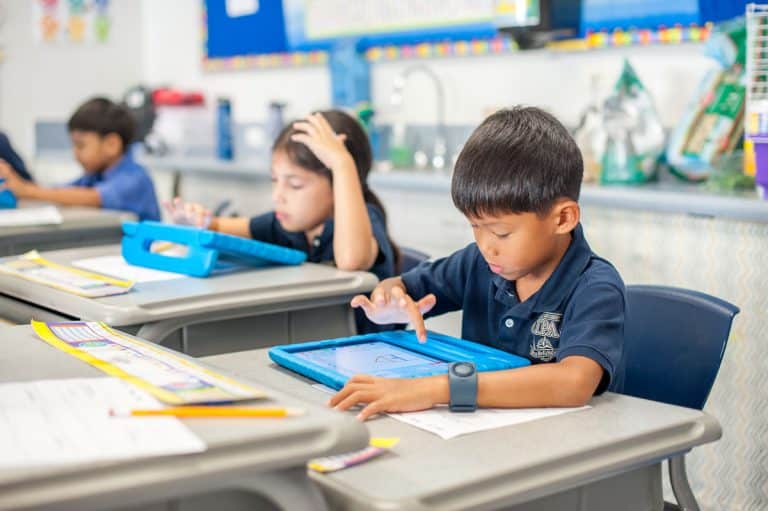 Academics Resources Safe Technology and Media image with children working on devices in a classroom