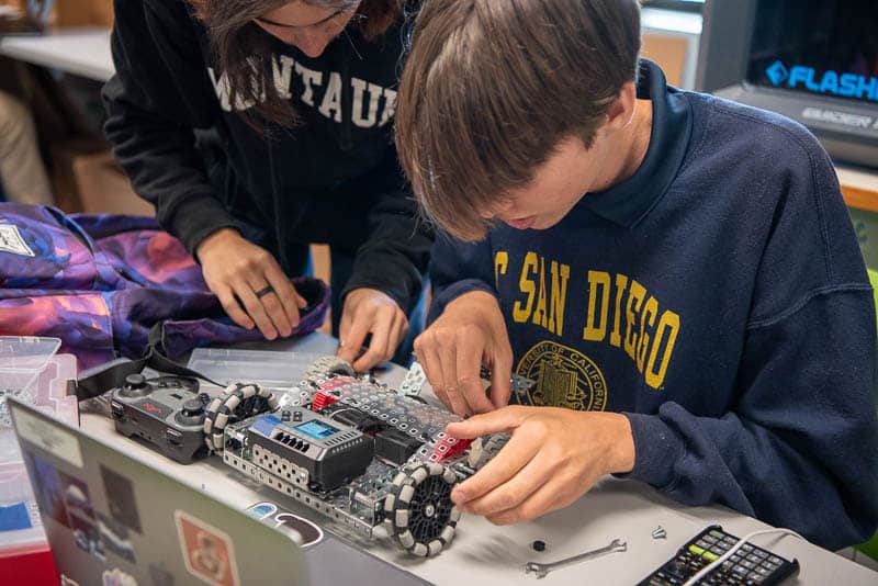 Two students working on a VEX robot.