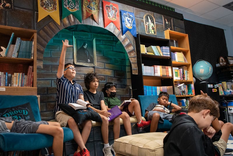 Students sitting in a recreation of the Hogwarts library.