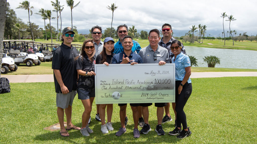 Golf tournament committee members holding giant check for $100,000.