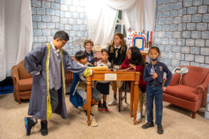 Group of students in period costumes recreating signing of Declaration of Independence.
